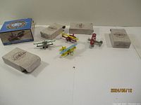 Photo showing all four miniature die cast biplanes with their original boxes placed behind