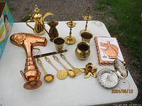 Photo showing all 18 pieces including pitcher, candlesticks, utensils, cups, flower decor, and plaque.