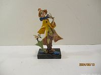 Front view of the detailed clown figurine showing the colorful clothing, facial features, and musical instrument.