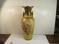 Front view of the large 24-inch decorative porcelain vase showing painted floral patterns, flared rim, and ornamental handles.