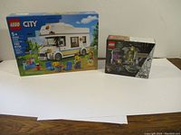 Photo of LEGO City Holiday Camper Van 60283 and a smaller LEGO Marvel set boxes on white background