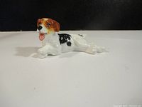 Side view of the Royal Doulton porcelain dog figurine showing detailed painted coat and lying posture.