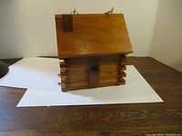Front view of wooden bird house showing entrance, door, and log-style construction.