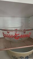 Full view of the large clear glass Pyrex bowl showing the red cherry and checkerboard design.