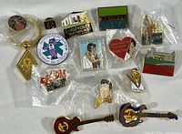 Full view of all collectible pins laid out including Elvis Presley and Hard Rock Cafe designs.