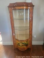 Front view showing curved glass door, three interior glass shelves and painted lower panel