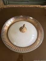 Round flush mount ceiling light fixture with white dome center, clear glass edge with gold pattern, and decorative brass fittings shown from the top.