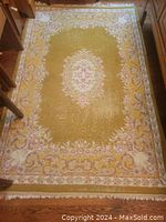 Full view of rug showing central medallion and border on hardwood floor