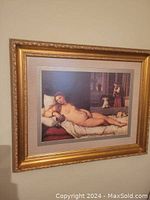 Front view of the framed Venus of Urbino print hanging on a wall, showing the print, cream mat, and detailed gold frame.