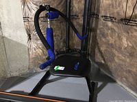 Photo of AB Doer Pro abdominal exercise machine showing the padded seat and foam padded handles in a basement setting.