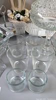 Photo showing clear glass candle holders, drinking glasses, cut glass compote and pedestal candy dish