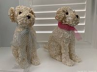 Front view of the pair of decorative dog sculptures covered with paper flowers, showing facial details and scarves