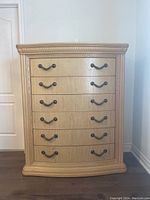 Front view of Bassett Furniture hi-boy style dresser showing six drawers with ornate metal handles.