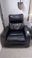 Front view of black electric recliner rocker chair showing full structure, armrests, and cushion condition.