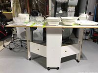 View of the full white folding table with dishes displayed on top showing the table design and size.