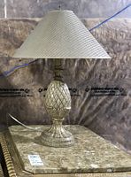 Full view of one lamp showing ceramic pineapple style base with crackled finish and woven cone-shaped shade.