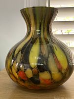Front view of Murano glass vase showing bulbous shape, multicolored inclusions, and glossy finish.