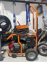Full view of Ridgid generator on orange steel frame with two wheels and handle