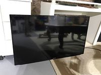 Front view of the Samsung TV showing black bezel and screen.