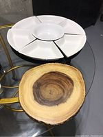 White ceramic serving dish set with six triangular compartments and central round bowl, displayed on a glass table alongside the Acacia wood cutting board.
