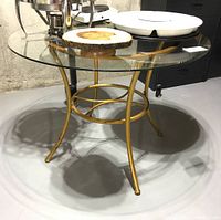 Full view of the round glass top table and coated metal base.