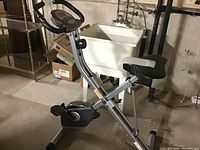 Side angle showing full exercise bike frame, pedals, digital display, and cushioned seat.