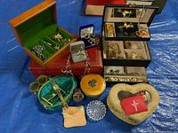 Wide shot showing multiple jewellery boxes, rhinestone pins, gold-tone wristwatch, beaded necklaces, shoe clips, rosary beads, ring holder, and small accessories.