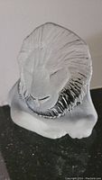 Full view of the clear glass lion figurine showing detailed mane and facial features.