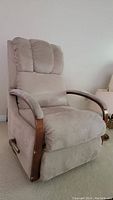 Front angled view of beige micro suede La-Z-Boy recliner showing padded segmented backrest and visible wooden armrests.