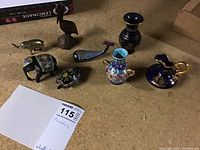 Overview of miniature figurines and decorative glass items on wooden surface