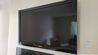 Samsung 46-inch flat screen TV mounted on wall with black bezel.