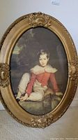 Full view of the vintage print in ornate oval resin frame showing the seated boy and detailed frame
