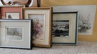 Five framed and unframed prints arranged together showing diverse subjects and frame styles