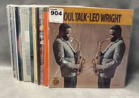 Stack of jazz vinyl records showing front cover of Soul Talk by Leo Wright with musician playing saxophone mirrored on cover.