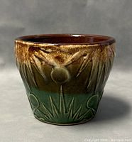 Front view of vintage Roseville Robinson planter showing glazed floral motifs in brown and green glaze.