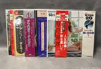 Front view of all five Japanese vinyl records showing colorful obi strips and cover art including woman reclining, harp, and portraits