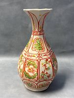 Front view of the antique ceramic vase showing hand painted designs of grapes, flowers, and bamboo in red and green on white.
