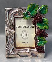 Front view of silver plated photo frame showing grape clusters and leaves decoration