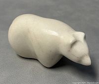 Top-front angle view showing the polished white marble bear figure, smooth contours, and minor surface marks.