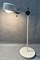 Full side view of MCM Bazz desk lamp showing adjustable arm and dome shade on weighted base