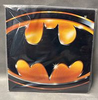 Front cover of the vinyl record album featuring the Batman symbol in orange and black.