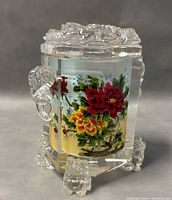 Front and side view of Chinese crystal snuff bottle showing colorful reverse inside painted flowers and clear crystal body with detailed sculpting on top and feet.