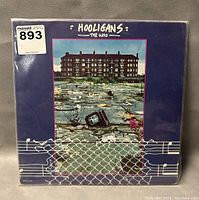 Front cover of 'Hooligans' vinyl album by The Who showing artwork of a flooded area with TV set and building.