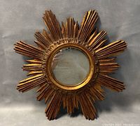 Front view of carved wood starburst mirror with gilt finish