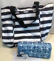 Photo showing two insulated tote bags: one black and white striped with black handles and a snap closure, the other blue with a pixel-based pattern and a snap closure flap.