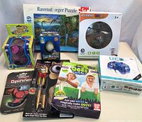 Full view of all toys including puzzle, flying ball, fidget spinner, glow sticks, ooze putty, constipation game and UFO maze toy