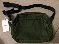 Dark green nylon Baggu fanny pack shown with adjustable strap and white product tag.
