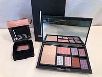 Photo showing Doucce eyeshadow palette open displaying 9 shades with mirror and small replacement eyeshadow with packaging.