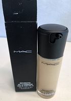 Photo of the MAC Matchmaster SPF 15 Foundation bottle and its black original box showing product and branding details.