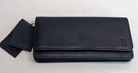 Front view of an unopened black leather Pelle ladies wallet with tags attached, showing the smooth texture and fold-over flap.